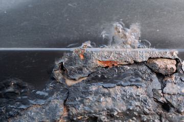 A fragment of a rusty car fender. Aggressive corrosion. Selective focus. Closeup