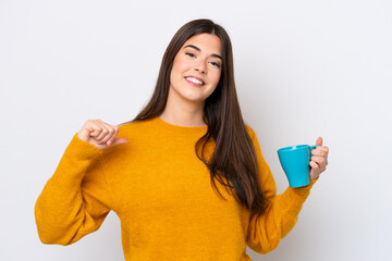 Young Brazilian woman holding cup of coffee isolated on white background proud and self-satisfied