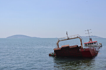 A red ship capsized in a storm off the coast of Maltepe (Istanbul) with the Princes Islands in the Sea of Marmara in the background