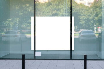 Blank white advertising poster in the shopwindow