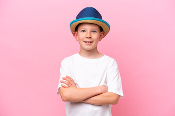 Little caucasian boy wearing a hat isolated on pink background smiling a lot