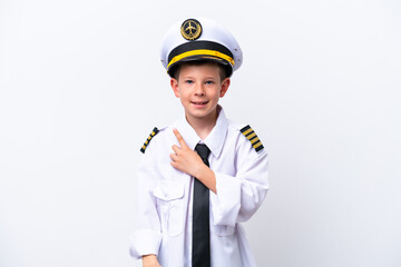 Little airplane pilot boy isolated on white background pointing to the side to present a product
