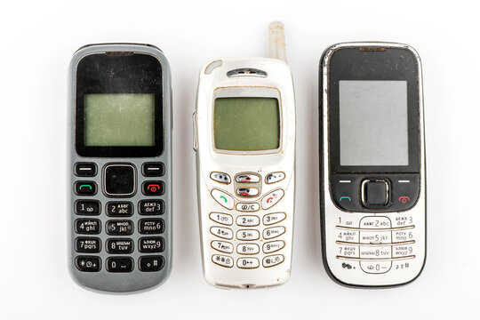 Old mobile phone in different colors. Retro technology of cellular devices located on a white background. Old technical display