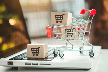Shopping online. cardboard box with a shopping cart logo in a trolley on laptop keyboard. Shopping service on The online web. offers home delivery.