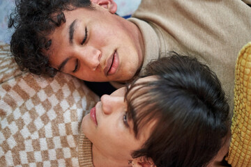 Passionate sexual gay couple in an intimate moment lying on the sofa at home