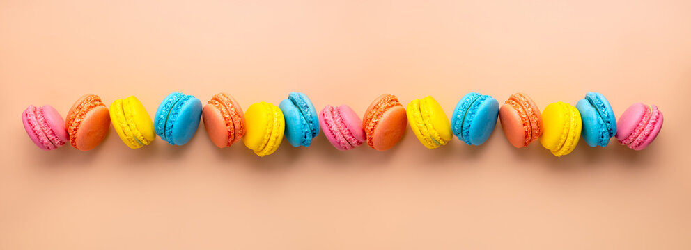 16 bright multicolored french sweet desserts - macaroons on a pastel background