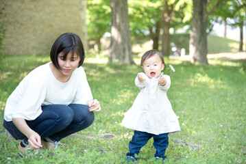 お花を触る1歳の女の子と母親
