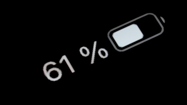 Timelapse - white smartphone battery level indicator running low - from 100 to zero percent: close up macro view of gadget display, screen, black background. Energy, power, digital, time lapse concept