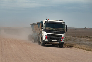 Overberg region, Western Cape, South Africa. 2022. Dirt road and dust flowing off the wheels of a truck and trailer in the Overberg region. South Africa.