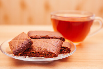 Chocolate cookies on the wooden table and tea on background