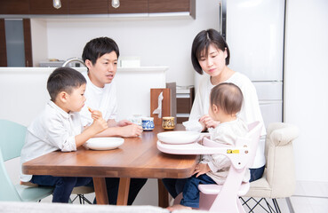 Fototapeta premium ダイニングテーブルでおやつを食べている家族