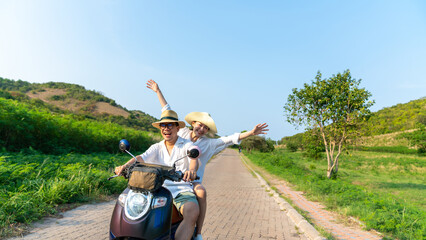 Happy Asian family couple riding motorcycle together while travel on tropical island mountain road...