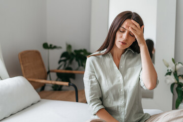 Young woman with headache in home interior