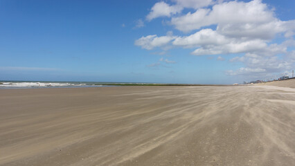 endless beach at the North Sea with sand blown by the wind in Oostende, Belgium
