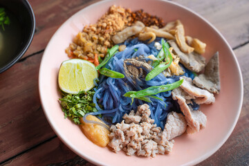 Tom Yum Pork Noodles with the purple color of noodles applied ingredients from the butterfly pea flower delicious spicy noodles with lemon, minced pork.