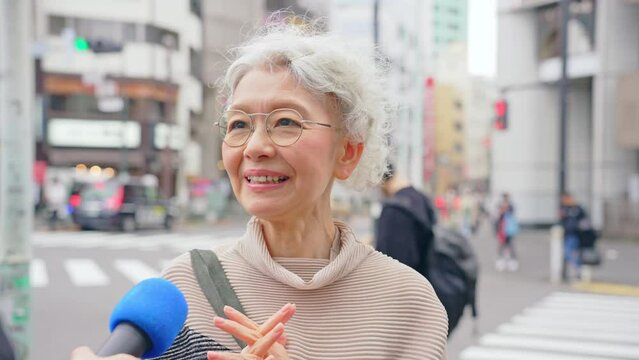 街頭インタビューを受けるシニア女性