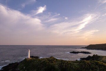 Fototapeta na wymiar 夕暮れの灯台と岬の風景