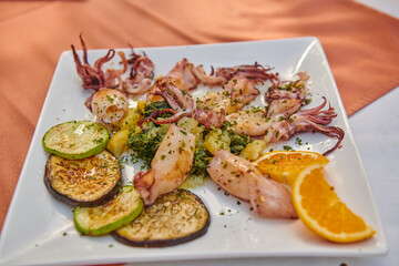 grilled octopus and grilled vegetables on a white plate