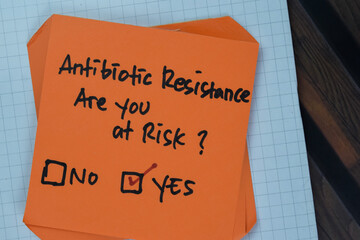 Concept of Antibiotic Resistance, Are you at risk? Yes write on sticky notes isolated on Wooden...