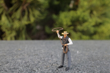 a mini figure cow boy galloping with lasso in hand
