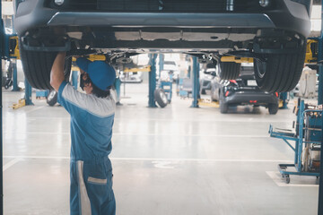 Employees who are checking engines at car service centre auto repair workshop