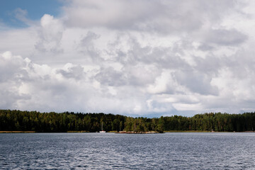 View from the sea in Turku Archipelago, Finland with small island and white clouds in blue sky