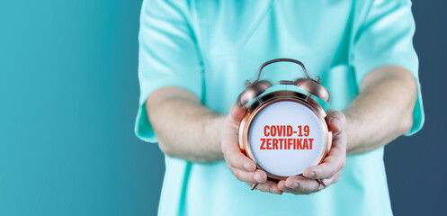 COVID-19-Zertifikat. Doktor zeigt Uhr/Wecker mit Text. Hintergrund blau