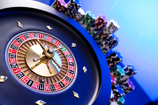Casino theme.  Gambling games. Roulette and poker chips on a blue background.