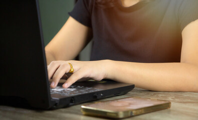 Fototapeta premium Female businessman hands using computer on desk, work outside the office and home concept