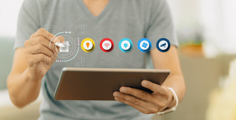 A man manages smart home automation, monitoring, and security with his tablet computer