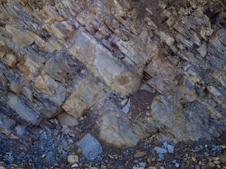 Texture of layers and cracks in sedimentary rock on cliff face. Cliff of rock mountain background. Rock slate in the Carpathian mountains, Ukraine. Cracks and layers of sandstone.
