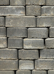 Regular shape blocks, texture, background. Paving slabs of gray blocks of flat shape, close-up. Pavement blocks in city park. Arrangement of a park way. Bricks or blocks of paving slabs laid in row