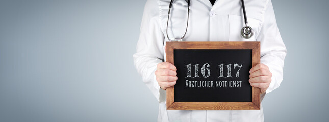 116 117 (Ärztlicher Notdienst). Arzt zeigt Begriff auf einem Holz Schild.