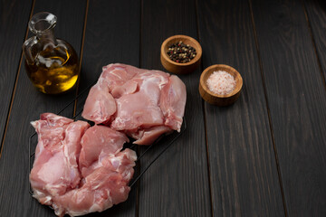 fresh raw rabbit meat with rosemary sprigs on a grill marinated on a dark background, open space