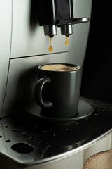 Espresso is poured into an espresso cup from a home coffee machine.