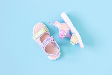 Stylish holographic sandals for kids on blue background. Shiny fashion summer shoes. Flat lay, Top...