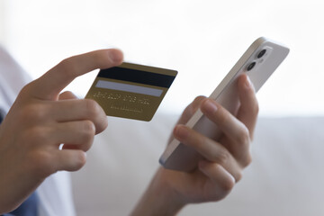 Female credit card user entering credit card data, security code for payment, using banking finance app on cellphone, shopping on Internet, buying goods, making online order. Close up of hands