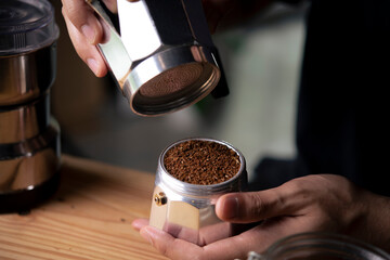 Barista holding moka pot with ground coffee in coffee shop. - 503239545