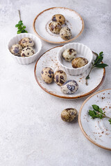 Bowl with quail eggs on light background