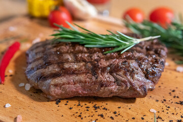 Grilled ribeye with rosemary, ajika, hot pepper, corn, tomato juice on a wooden board