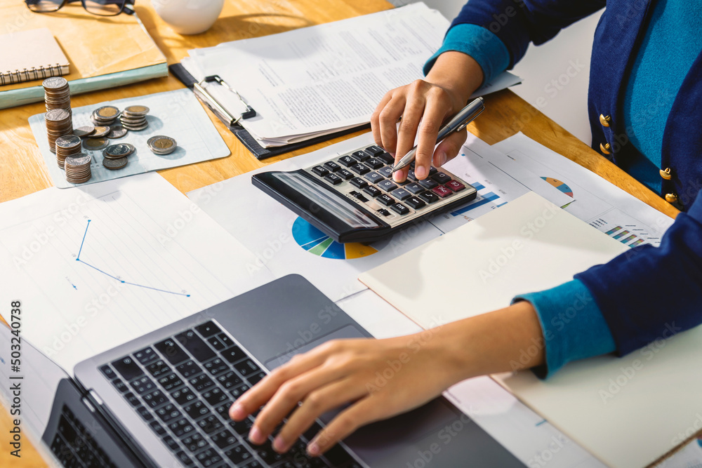 Aufkleber accounting concept. businesswoman working using calculator with money stack in office