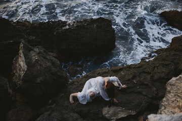 woman in a white dress lying on a stone in a white dress unaltered