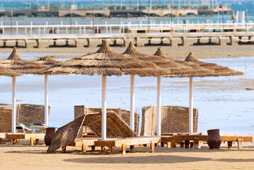 Empty beach in Egypt. Loungers and jetties without people. Holidays in Egypt. Beach at low tide.