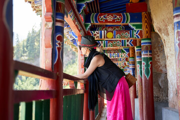 Obraz na płótnie Canvas asian woman looking at view from inside of an ancient tibetan building