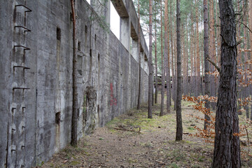 Obraz premium Różne żelbetonowe konstrukcje rozrzucone po lesie po opuszczonej fabryce amunicji w okolicy Nowogrodu Bobrzańskiego