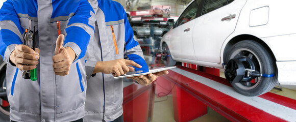 Auto mechanic analyzes and aligns automobile wheels. The car checks the wheel sensors on for wheels alignment