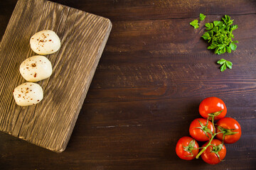 Goat cheese and fresh vegetables in the kitchen, juicy tomatoes, onions