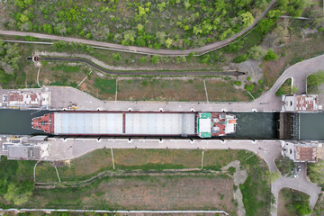 Cargo transportation. A cargo ship on the river is descending in one of the locks of the Volga-Don...