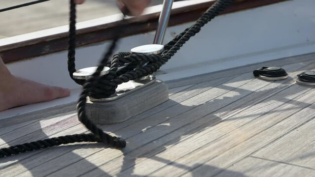 Lateral handheld shot of male hands tying a cleat hitch on the boat in Alicante port, Alicante, Spain - stock video