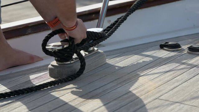 Lateral handheld shot of male hands tying a cleat hitch on the boat in Alicante port, Alicante, Spain - stock video